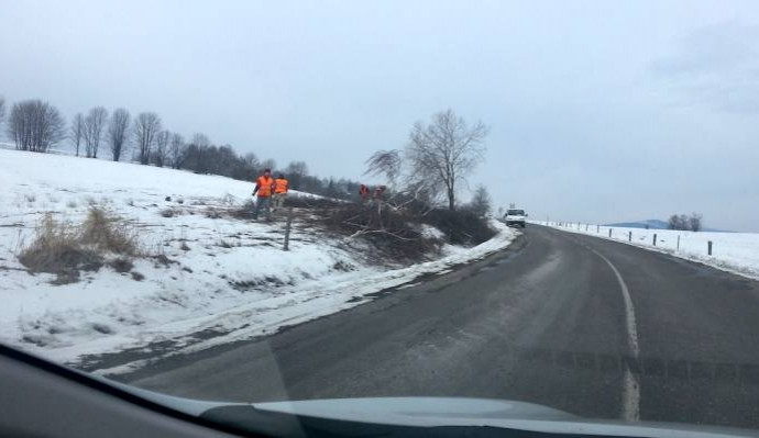 Pohled z automobilu na silnici, zasněžené okolí - ilustrační foto