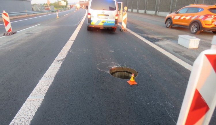 Řidič auta s přívěsným vozíkem na dálnici najel na uvolněný kanál. Náraz vozík vymrštil do vzduchu