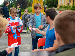 Petr Strapáč (v modrém) předává podepsané kartičky