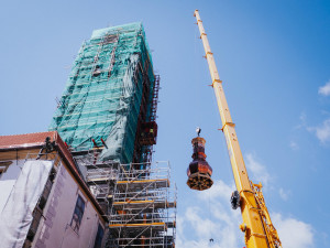 FOTO/VIDEO: Jeřáb dnes na olomouckou radnici vyzvedl prostřední část opravené věže