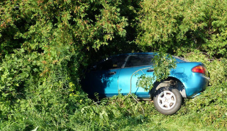 Řidička nezvládla řízení a skončila v živém plotě blízkého domu. Foto z místa nehody.