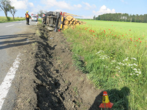 Opilý řidič nezvládl kamion plný dřeva a převrátil ho na bok. Pak se snažil utéct