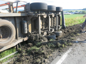 Opilý řidič nezvládl kamion plný dřeva a převrátil ho na bok. Pak se snažil utéct
