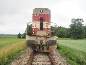 Projíždějící vlak smetl traktor, ten se po nárazu rozlomil
