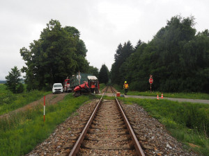 Projíždějící vlak smetl traktor, ten se po nárazu rozlomil