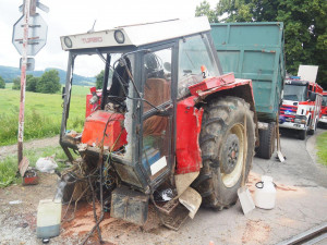 Projíždějící vlak smetl traktor, ten se po nárazu rozlomil