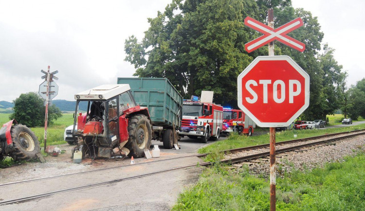 Projíždějící vlak smetl traktor, ten se po nárazu rozlomil.