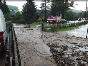 Silný déšť zvedl říčku Bělou na Jesenicku na třetí stupeň, zaplavila silnici. Hasiči čerpají vodu