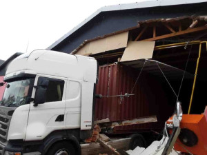 Neplánovaná demolice. Kamion při výjezdu z haly utrhl kus zdi, vůz vyprošťují hasiči