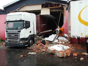 Neplánovaná demolice. Kamion při výjezdu z haly utrhl kus zdi, vůz vyprošťují hasiči