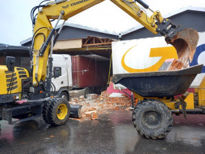 Neplánovaná demolice. Kamion při výjezdu z haly utrhl kus zdi, vůz vyprošťují hasiči