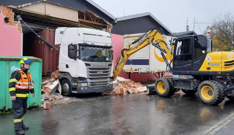 Neplánovaná demolice. Kamion při výjezdu z haly utrhl kus zdi, vůz vyprošťují hasiči
