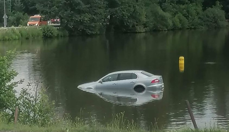 Smůla při parkování. Řidič v Kostelci špatně zajistil auto, to se rozjelo a skončilo v rybníku