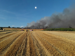 Čtrnáct jednotek hasičů bojuje s požárem na poli u Hranic. Oheň zasáhl desítky hektarů