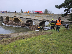Očista po povodňové hrozbě: Pod historický most v Litovli se spustili hasiči, odklízeli naplavené kmeny