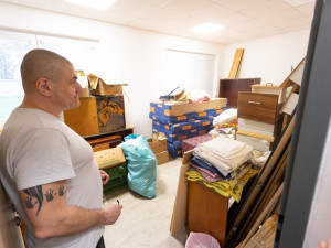 Jeden z klientů centra ukazuje sklad s materiálem a nábytkem