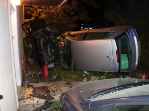 Řidič se dvěma promile vyletěl v Nových Zámcích ze zatáčky. Naboural zaparkované auto a dům