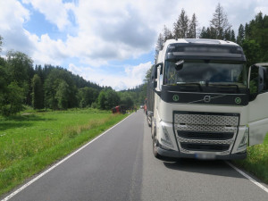 Kamion na úzké silnici u Hanušovic předjížděl Tatru plnou kamene. Skončila na boku v příkopu