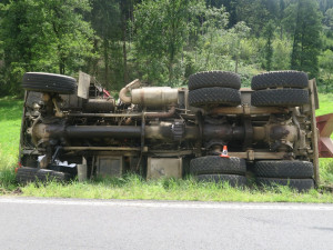 Kamion na úzké silnici u Hanušovic předjížděl Tatru plnou kamene. Skončila na boku v příkopu