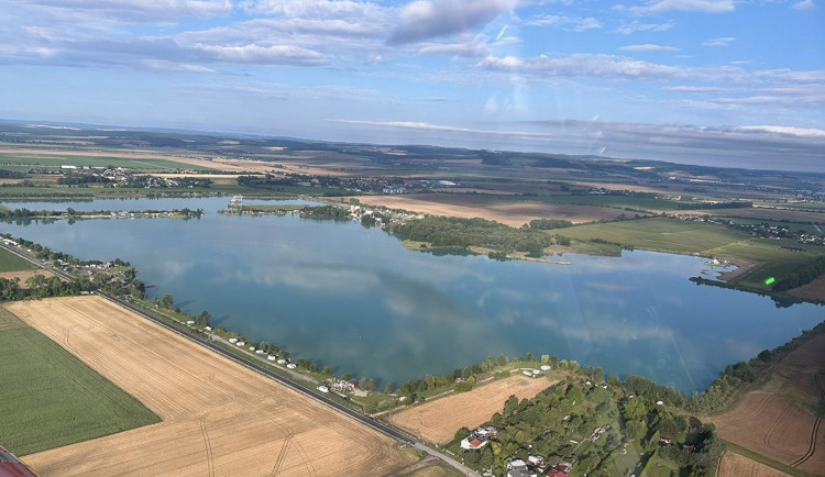 Pohled na pískovnu Náklo a v dolní části nalevo na opravenou silnici III/44620