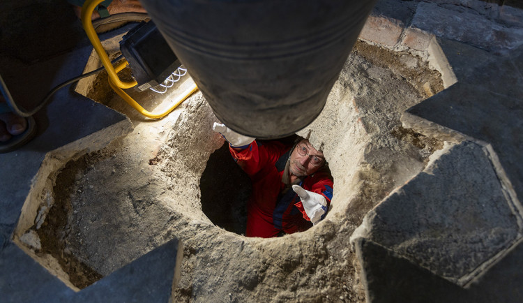 Archeolog Robert Zatloukal si bere nádobu pro uložení dalšího materiálu z podzemní místnosti pod kaplí