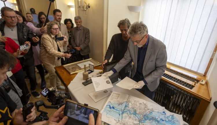 Primátor Miroslav Žbánek ukazuje předměty uložené v časové schránce