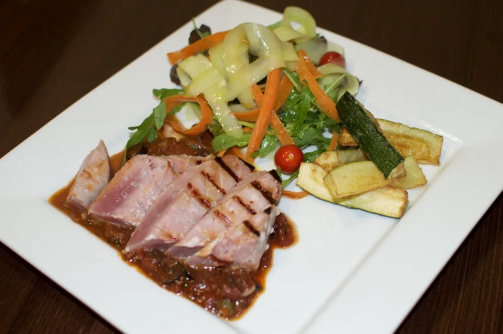 Grilovaný steak z čerstvého tuňáka s červeným vínem, kapari a olivovou omáčkou, cuketové hranolky a svěží míchaný salát