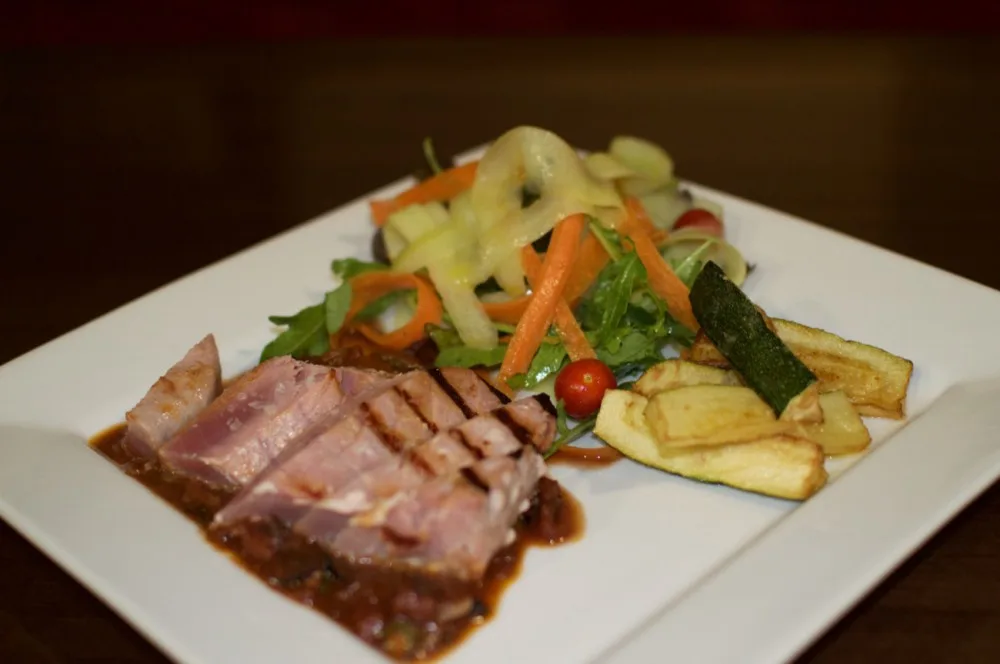 Grilovaný steak z čerstvého tuňáka s červeným vínem, kapari a olivovou omáčkou, cuketové hranolky a svěží míchaný salát