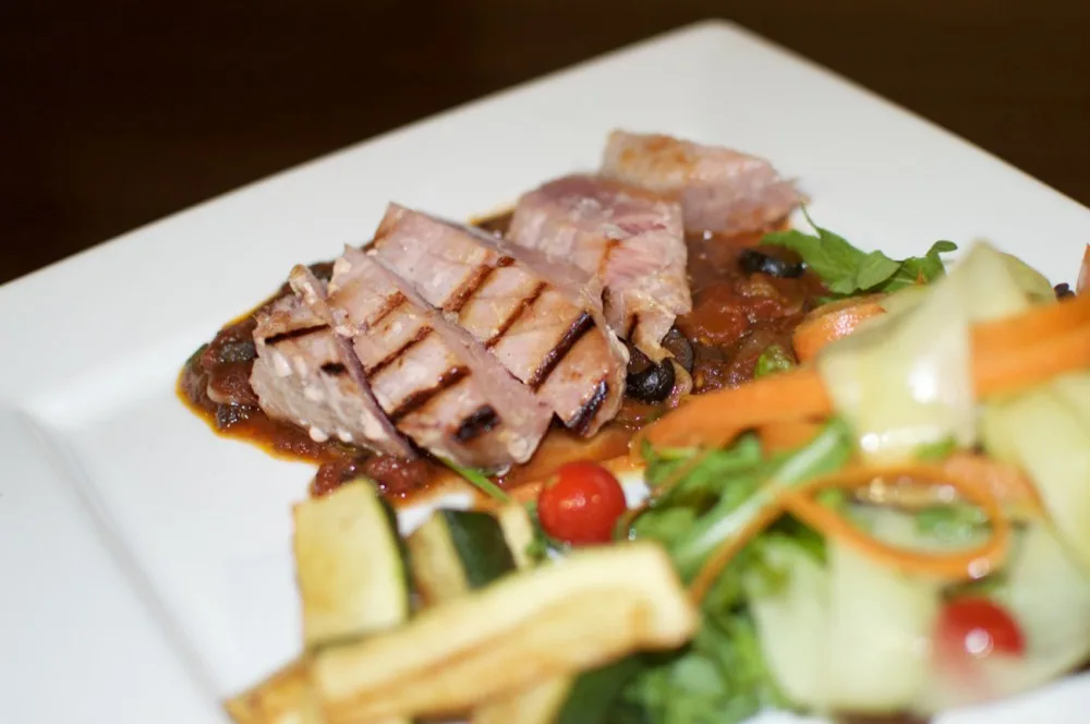 Grilovaný steak z čerstvého tuňáka s červeným vínem, kapari a olivovou omáčkou, cuketové hranolky a svěží míchaný salát