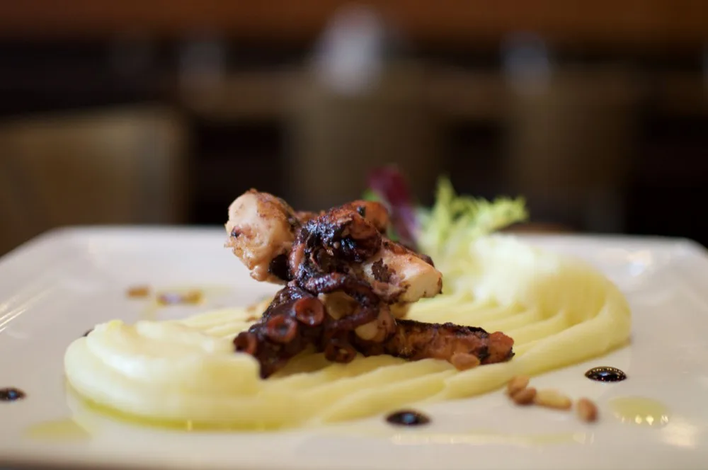 Grilovaná chobotnice, citronové pyré, smažené pinie, rukola