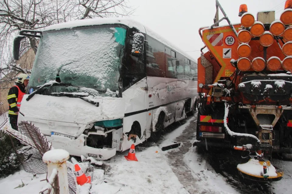 Autobus se srazil se sypačem a skončil v plotu rodinného domu, řidič byl převezen do nemocnice