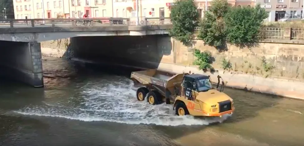 VIDEO: Stavební stroje se brodí korytem Moravy a odvážejí suť ze zbouraného mostu. Podívejte se