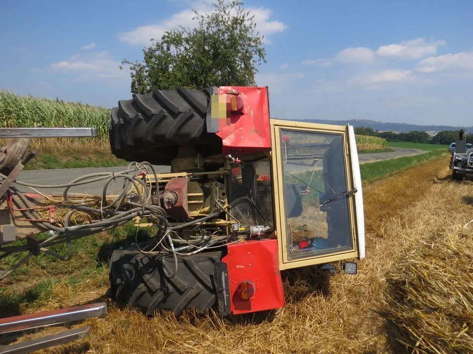 Traktorista jel příliš blízko krajnice, se strojem i s převáženou slámou skončil převrácený mimo silnici