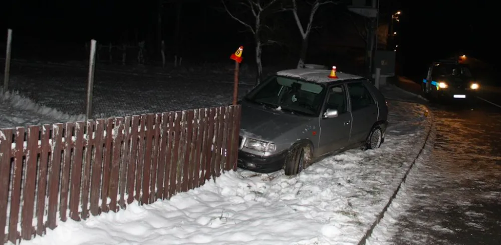 Opilý řidič nezvládl na letních gumách zatáčku a skončil v oplocení domu