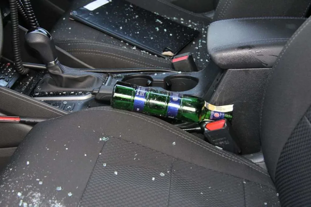 FOTO: Mladík bezdůvodně zaútočil na policistu, který seděl v autě. Na služebně pak prokopl dveře