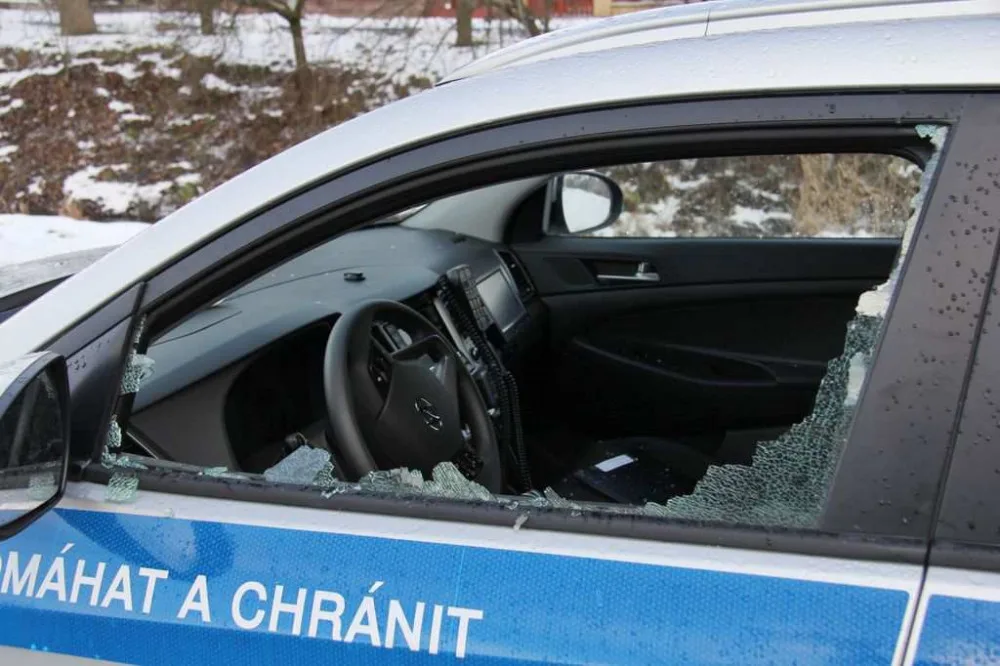 FOTO: Mladík bezdůvodně zaútočil na policistu, který seděl v autě. Na služebně pak prokopl dveře