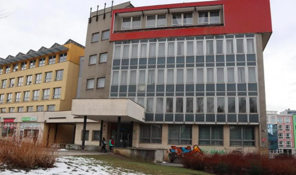 Budova, v níž se budou učit budoucí zdravotníci, původně sloužila coby Dům politické výchovy (na snímku vpravo). Krček, který je dnes již zaslepený, vedl do budovy, která byla sídlem KSČ. Dnes v tomto objektu sídlí poliklinika (na snímku vlevo)