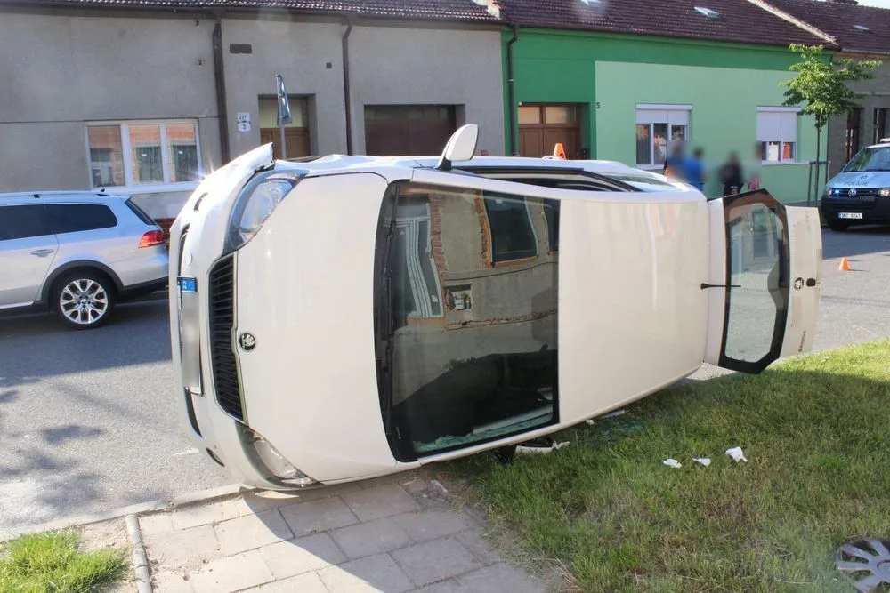 Žena bez řidičáku při couvání nabourala projíždějící auto. To skončilo na boku