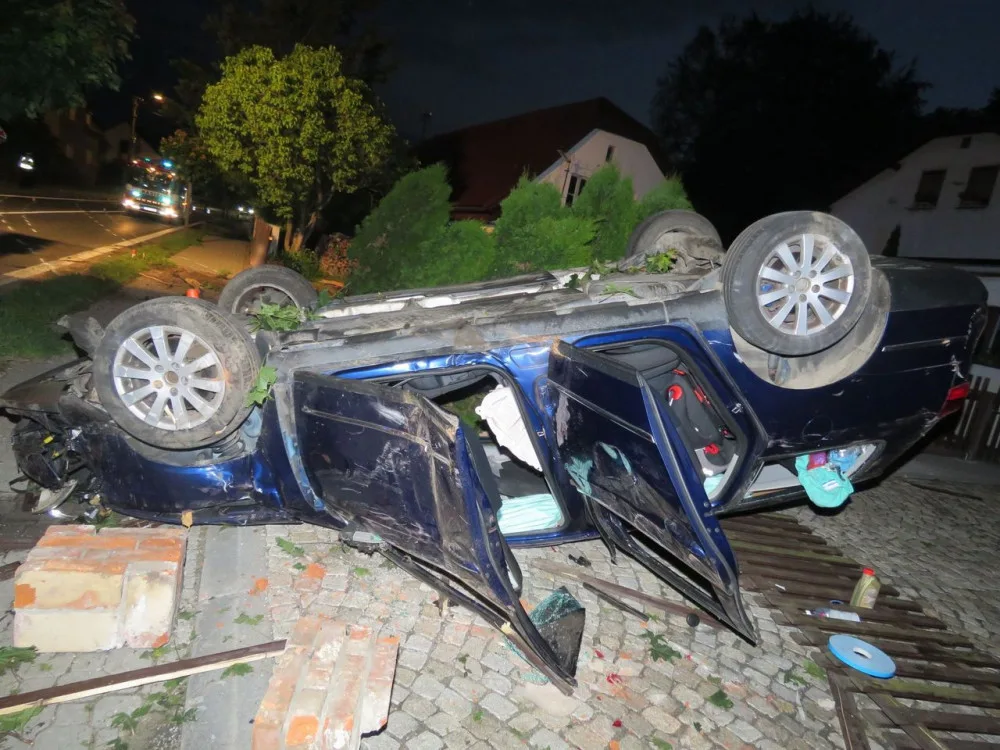 FOTO: Muž nezvládl řízení. Zdemoloval plot, otočil auto na střechu a nadýchal dvě promile