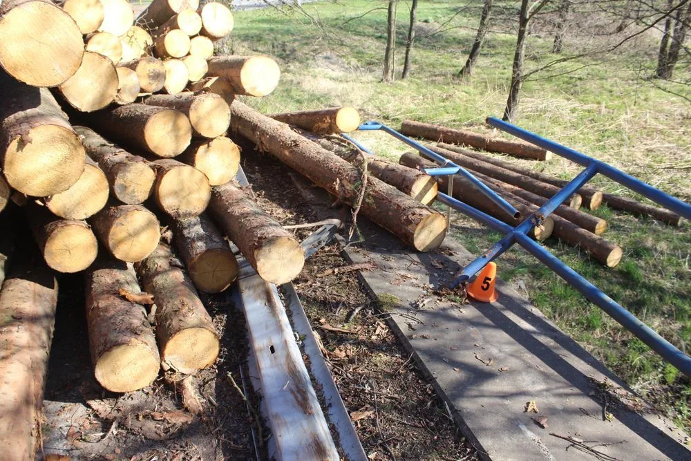 Řidič při projíždění zatáčkou převrátil přívěs s dřevěnými kládami