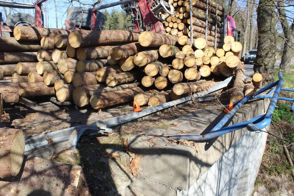 Řidič při projíždění zatáčkou převrátil přívěs s dřevěnými kládami