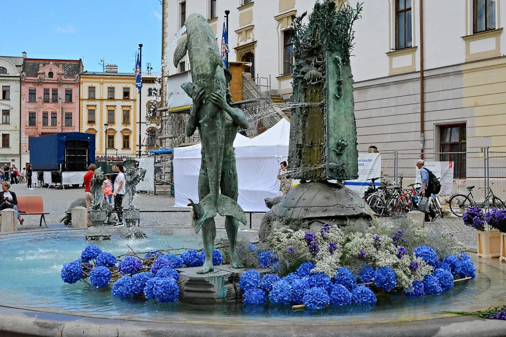 Po Sloupu Nejsvětější Trojice vykvetla i vedlejší Arionova kašna. Tentokrát bílými a modrými květy