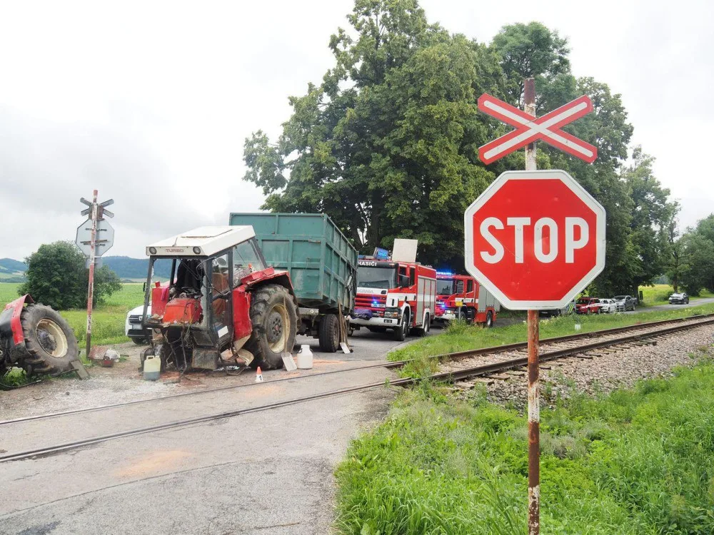 Projíždějící vlak smetl traktor, ten se po nárazu rozlomil.