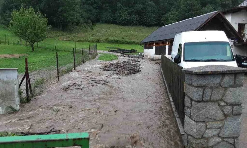 Silný déšť zvedl říčku Bělou na Jesenicku na třetí stupeň, zaplavila silnici. Hasiči čerpají vodu