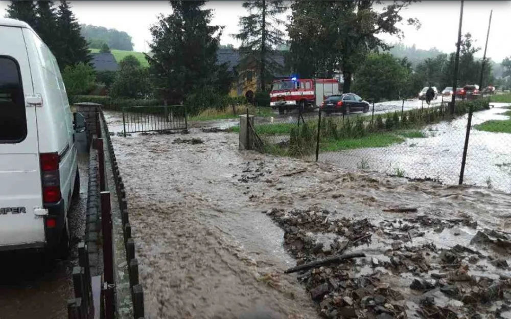 Silný déšť zvedl říčku Bělou na Jesenicku na třetí stupeň, zaplavila silnici. Hasiči čerpají vodu