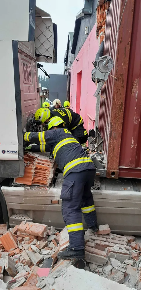 Neplánovaná demolice. Kamion při výjezdu z haly utrhl kus zdi, vůz vyprošťují hasiči