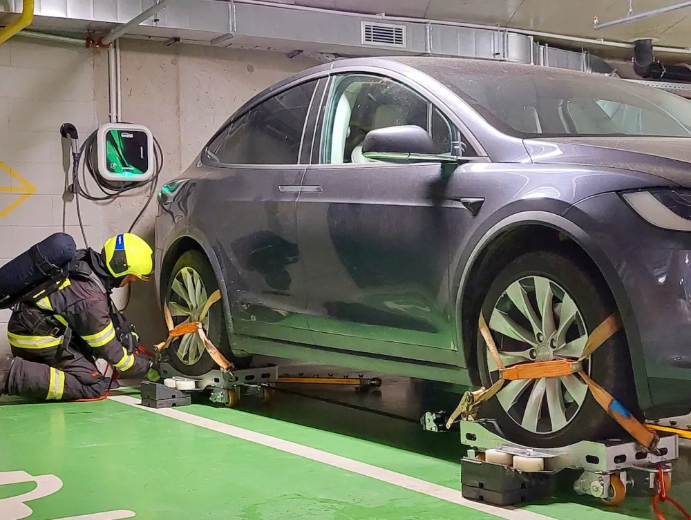 Požár elektromobilu v garážích. Hasiči cvičili, jak u hořícího vozidla postupovat