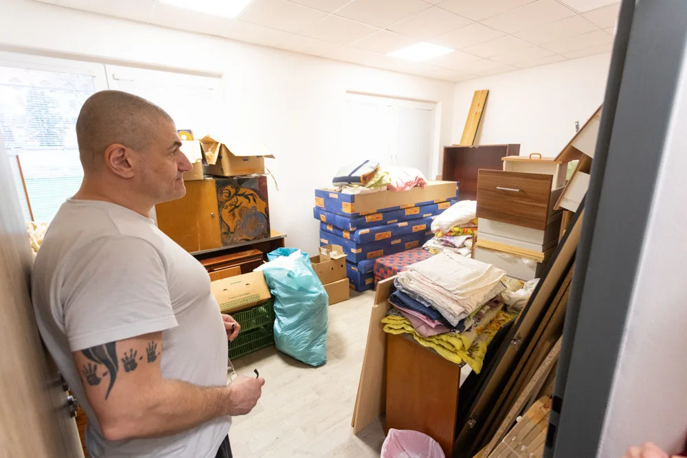 Jeden z klientů centra ukazuje sklad s materiálem a nábytkem