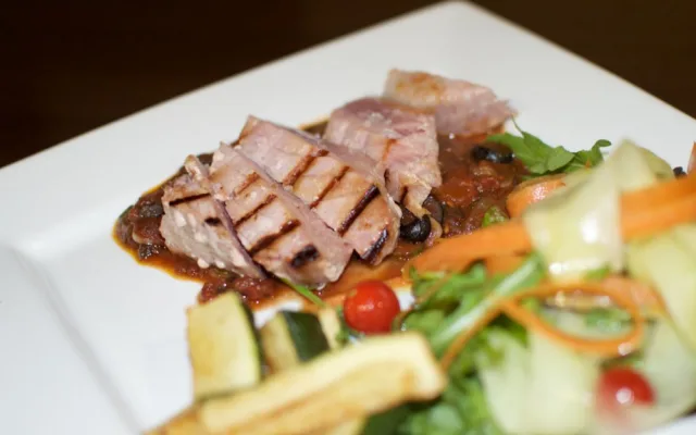 Grilovaný steak z čerstvého tuňáka s červeným vínem, kapari a olivovou omáčkou, cuketové hranolky a svěží míchaný salát