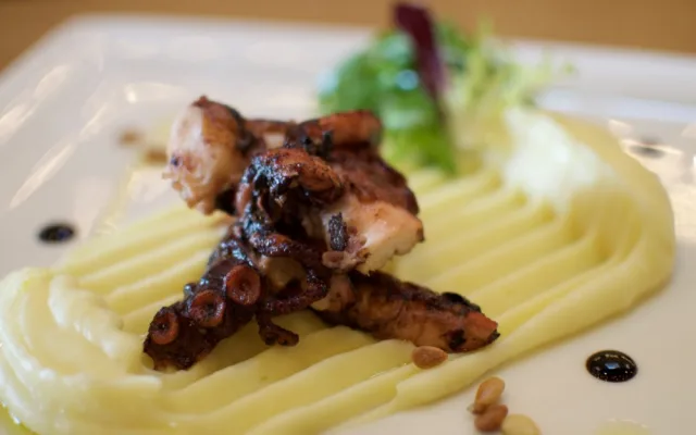 Grilovaná chobotnice, citronové pyré, smažené pinie, rukola